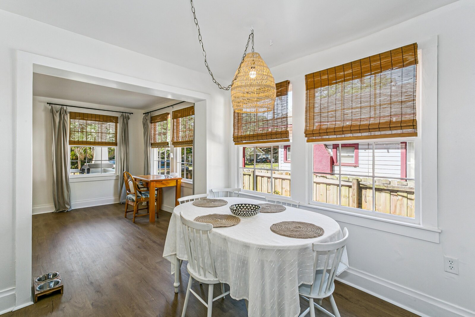 Dining nook with round table, woven pendant, and natural light