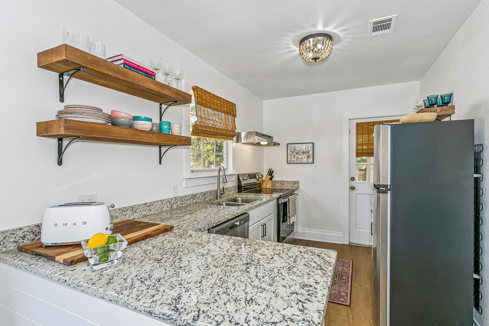 Bright kitchen with open shelving and granite countertops
